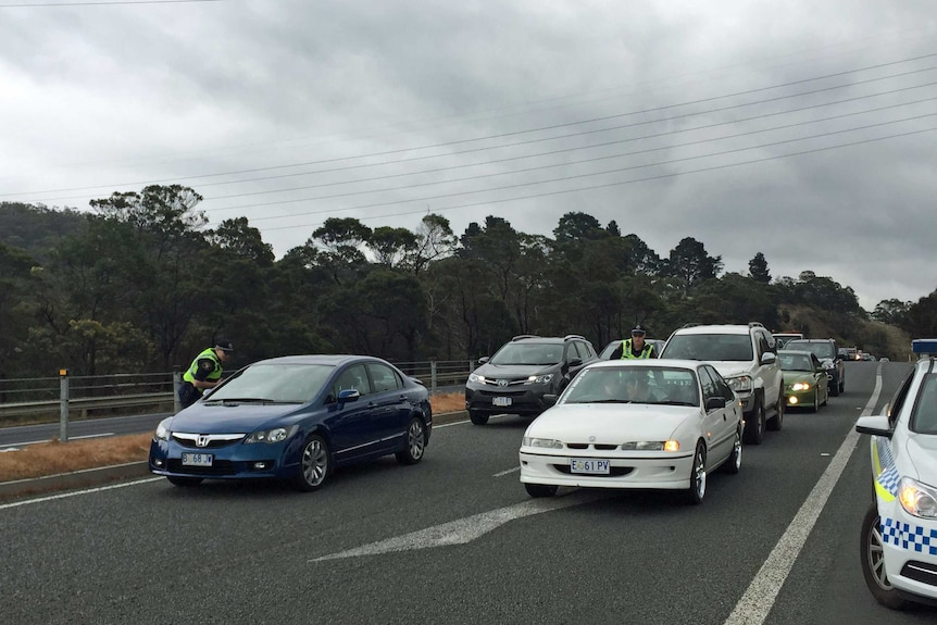 Police check cars at one of several roadblocks set up after a prisoner escaped from Risdon Prison.