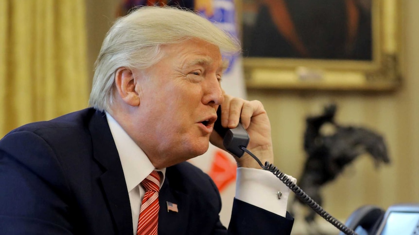Donald Trump on the phone as he sits at his Oval Office desk
