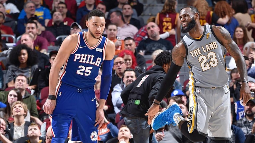 LeBron James smiles at Ben Simmons on the court.