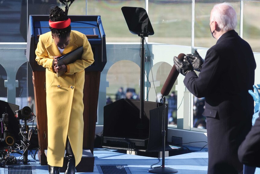 Poet Amanda Gorman takes a bow as US President Joe Biden applauds her at his inauguration ceremony