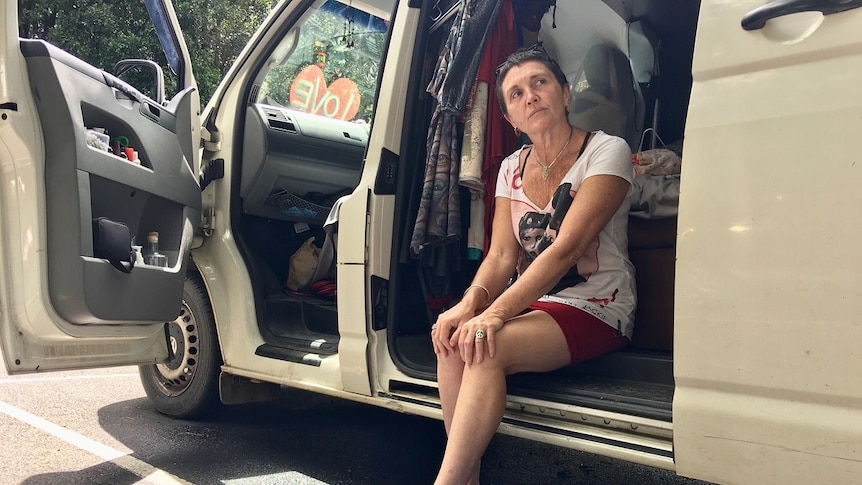 A woman sitting on the step of her van