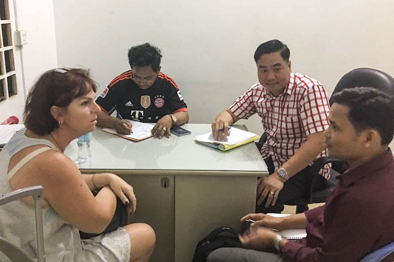 Tammy Davis-Charles is questioned by officials in Phnom Penh on Sunday in a photograph supplied by police