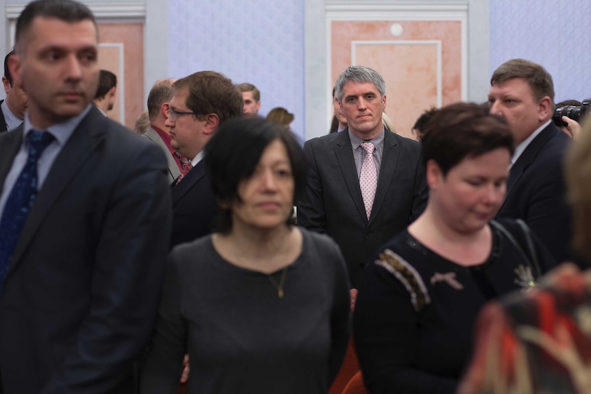 Members of Jehovah's Witnesses react in a court room after the judge's decision.