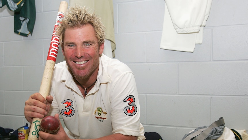 Shane Warne holds a stump in the changing rooms