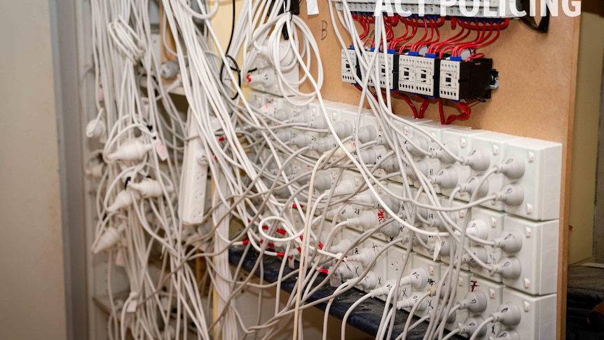 A large electrical board with multiple cords coming from it