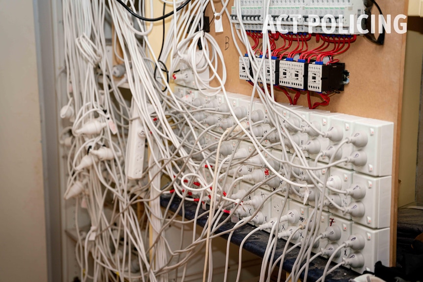 A large electrical board with multiple cords coming from it