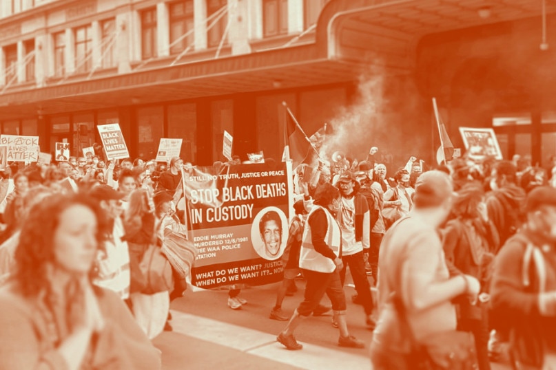  black and white photo of people protest with a banner saying "stop black deaths in custody".