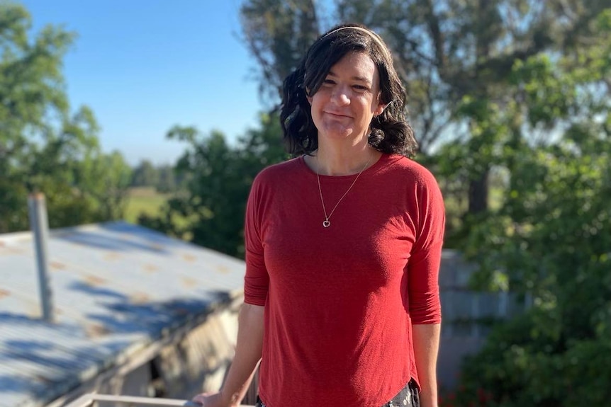 Claire Scott stands on a balcony and poses for a photo.