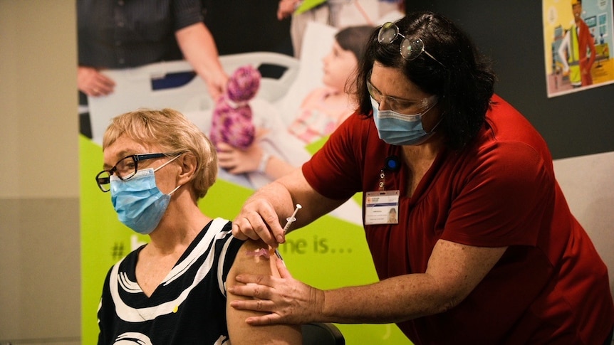 A woman inserts a needle into another woman's arm.