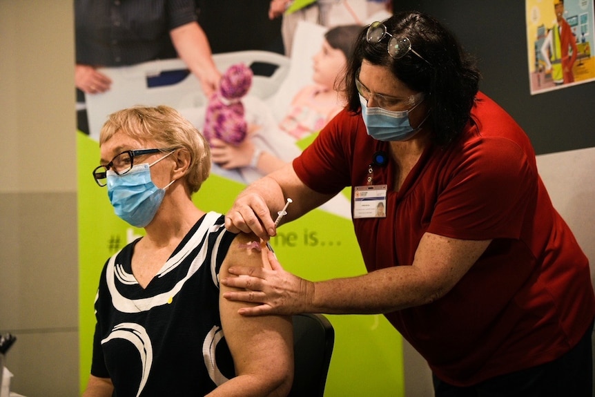 A woman inserts a needle into another woman's arm.