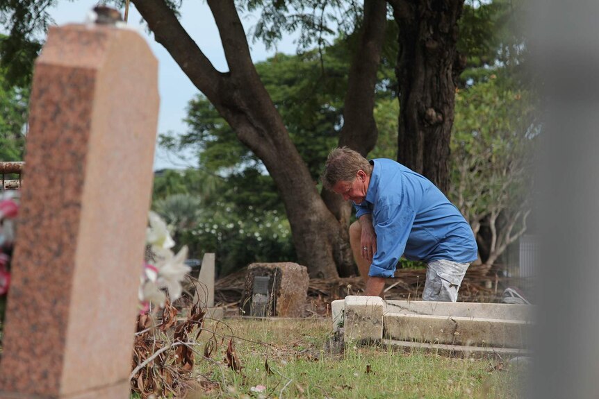 A photo of Gary Gallagher in the Gardens Cemetery, leaning over Cecil Northover's grave.