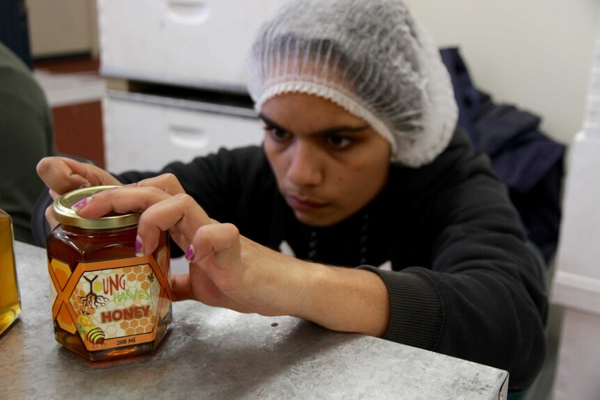 A job seekers applies the finishing touches to a jar of honey