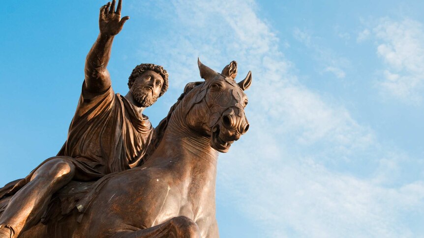 The Equestrian Statue of Marcus Aurelius in Rome, Italy. The bronze statue is photographed against a blue sky.