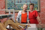 two women smiling at a cash register in a fashion store