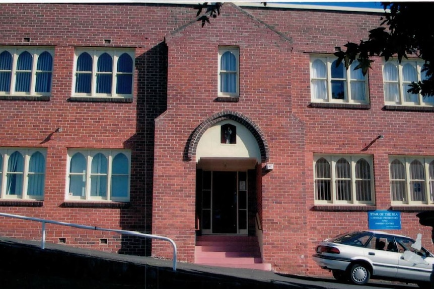 A red brick building with a white car in front of it.