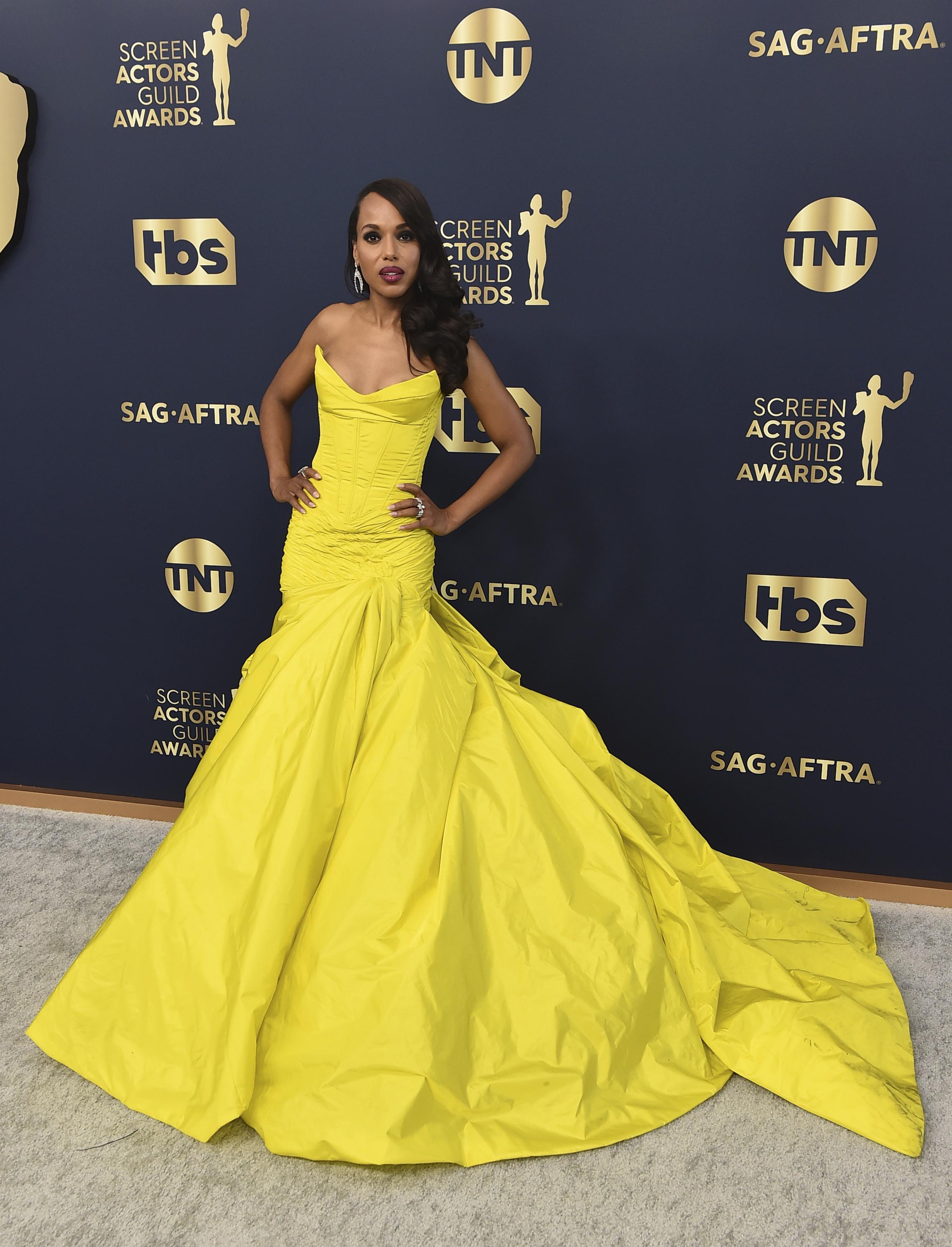 Kerry Washington wears a bright yellow gown with a voluminous skirt. 