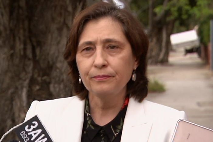 A woman with dark hair and a white jacket.