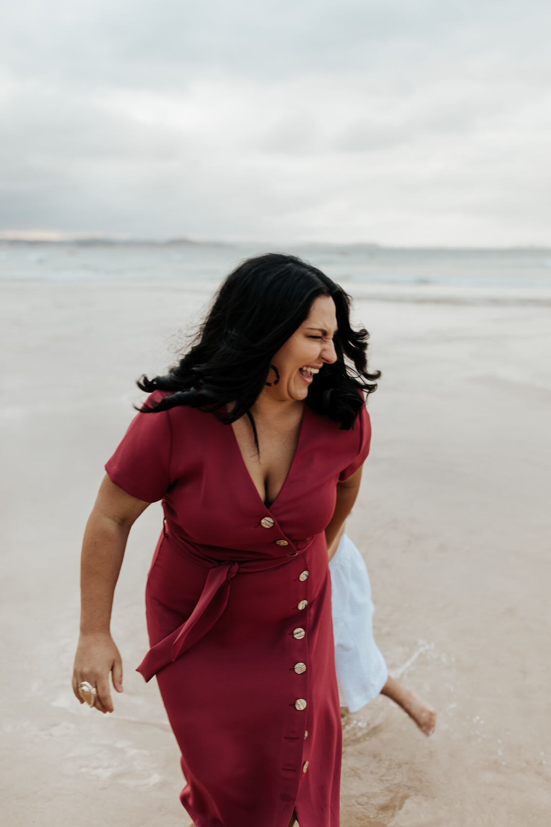 Woman on beach laughing. 