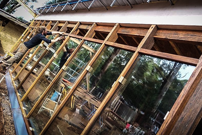 An image of a worker installing double glazed glass to the building.