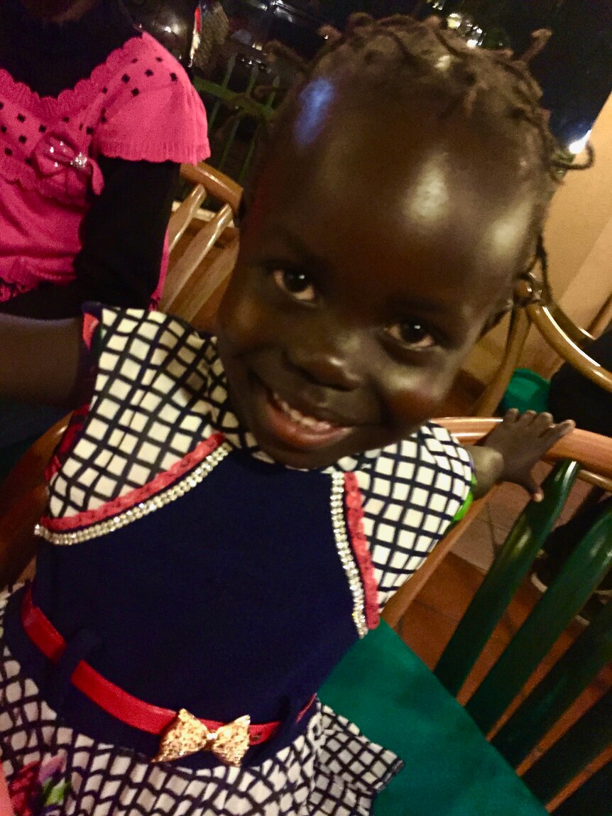The young Sally Sara from Uganda smiles up at the camera.