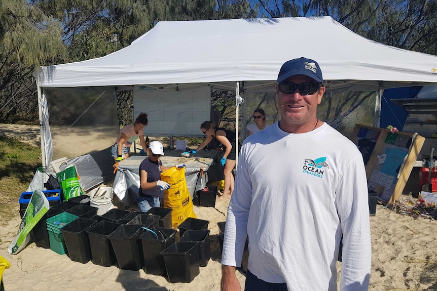 A man standing in front of the rubbish sorting tent on Fraser Island