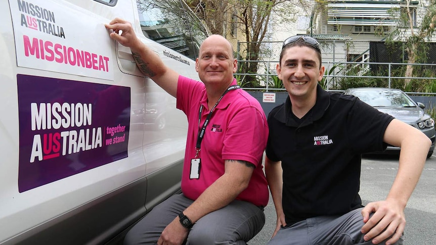 David McKeown and Mathew Sampson crouch beside their Missionbeat van