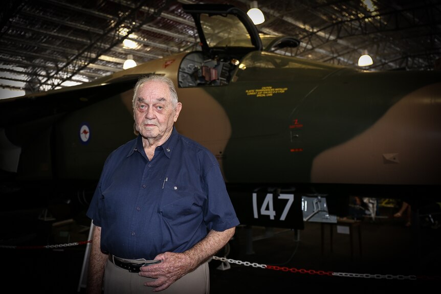 Milton Cottee standing in front of an F-111 plane