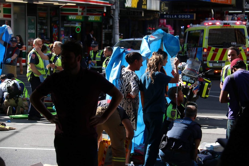 Paramedics treat people hit by a car that ploughed through a pedestrian crossing on Flinders Street.