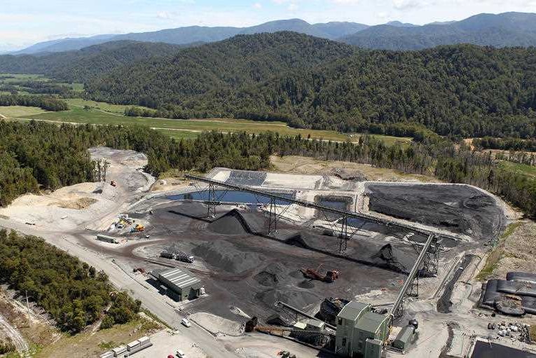 Aerial view of the coal processing area of the mine with blue sky and green hills in the background