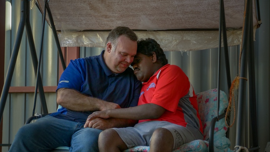 A man and his 18-year-old brother on a swing seat