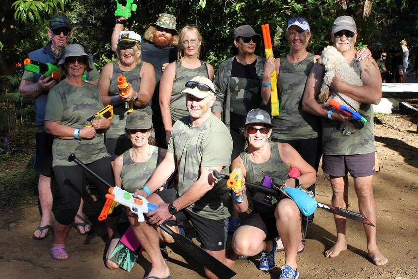 People dressed in camouflage gear with plastic water pistols