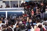 A crowd of people surrounds police and correctional workers outside the Topo Chico prison in Mexico.