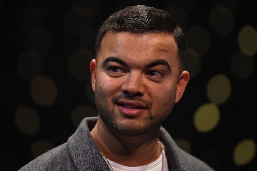 Guy Sebastian speaks on a stage.