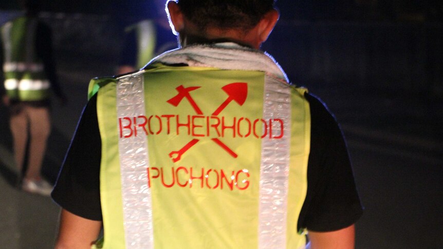 A man with the brotherhood logo printed on his shirt.
