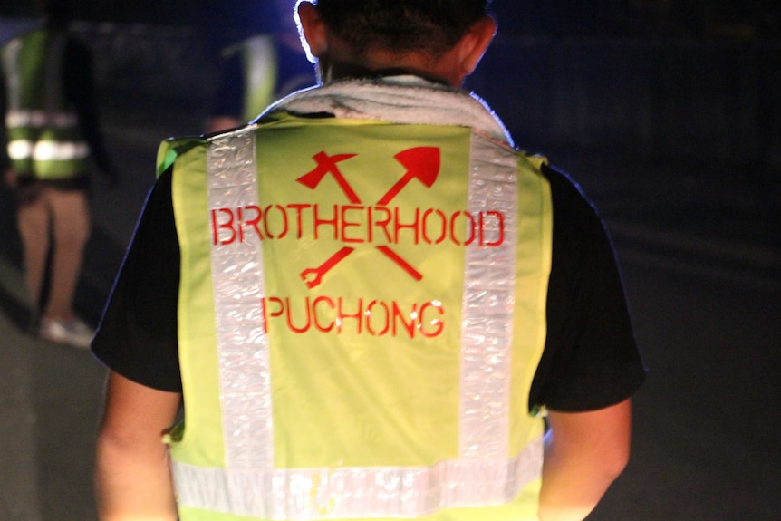 A man with the brotherhood logo printed on his shirt.