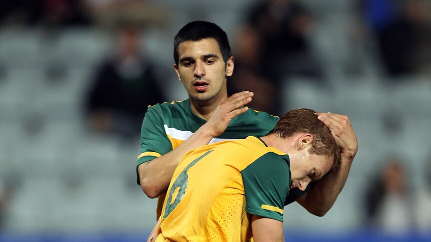 Scoreless draw ... Australia's Oliver Bozanic is congratulated after making a goal-saving tackle.