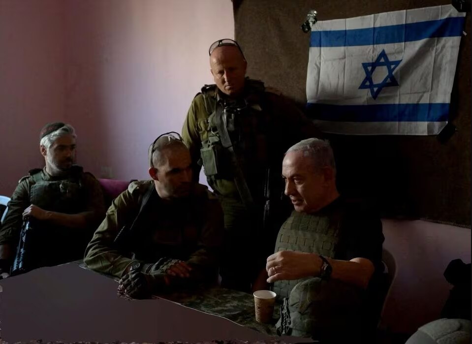 Four men dressed in army clothing sit at a table