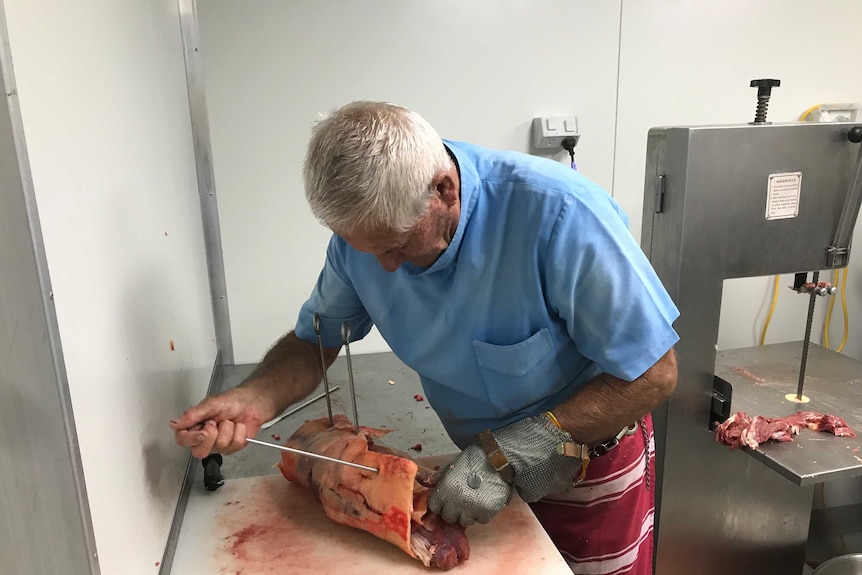 A worker on Trevor Welsh's property prepares a rolled roast