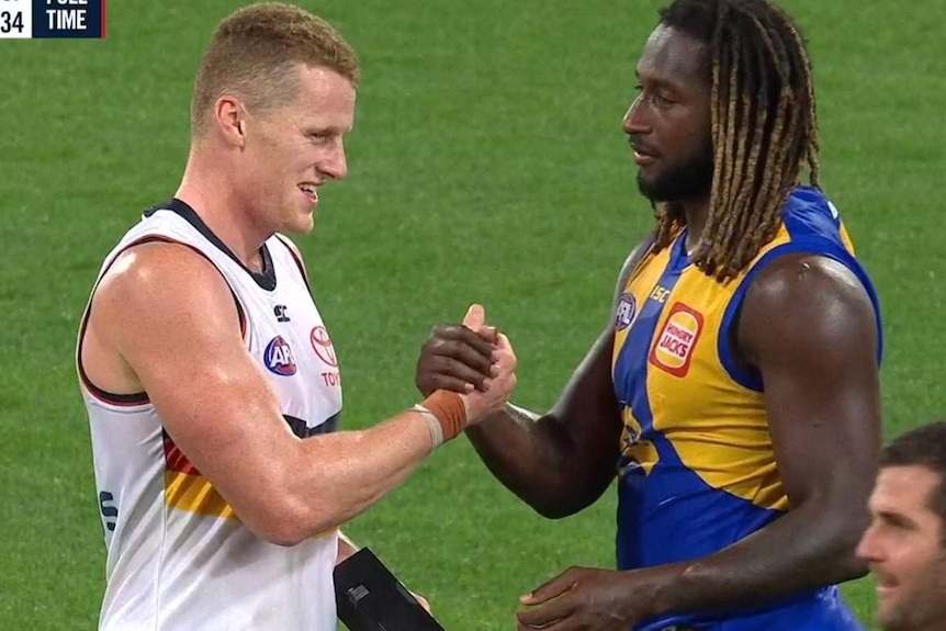 Screenshot of TV broadcast. Naitanui and O'Brien shake hands and smile.