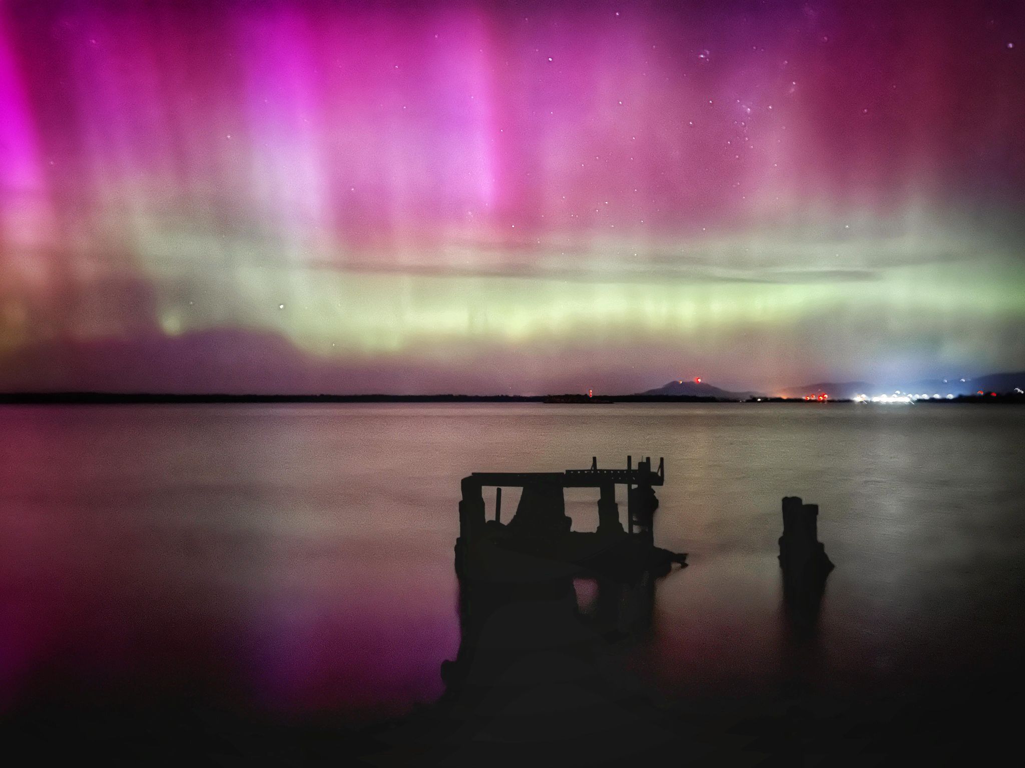 Purple lights in the sky over water.
