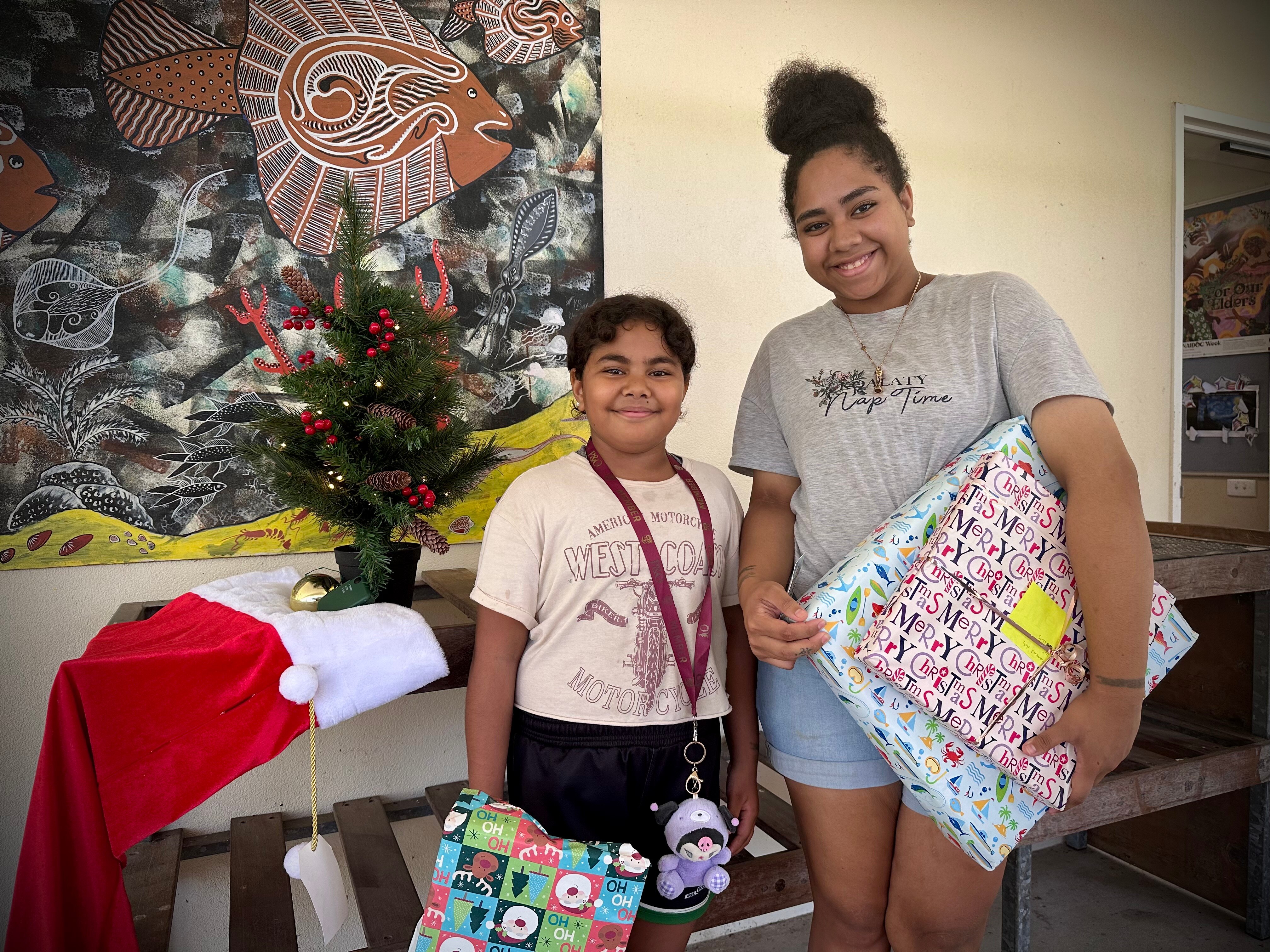 two women holding the presents