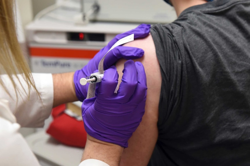 A patient is injected with a vaccine during a clinical trial.