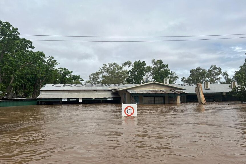 The Crossing Inn pub in Fitzroy Crossing inundated by floodwaters, with the water level almost up to the roof.