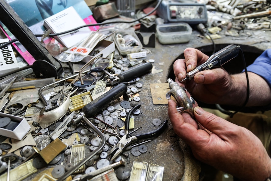 Designer Dan Flynn working on a platypus at his cluttered desk.