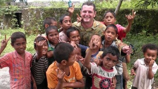 Brendan Larkin with children in Timourese Leste.