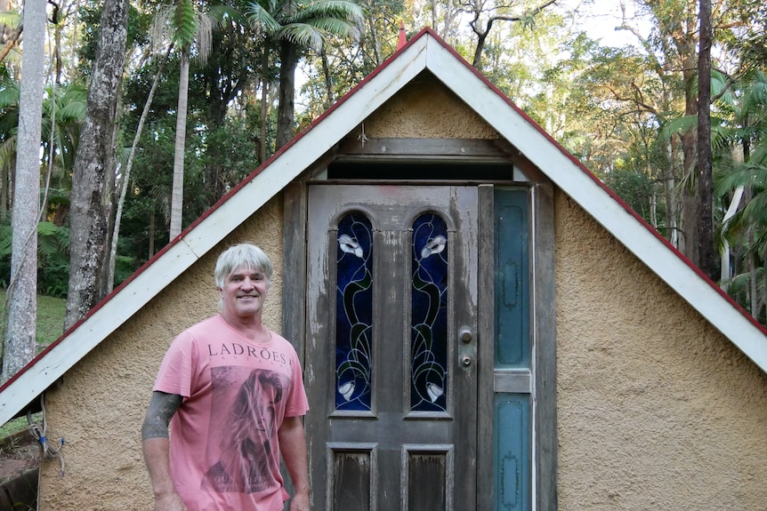 Fantasy Glades Owner Jeffrey Crowe stands in front of a timber door with led-lighting 