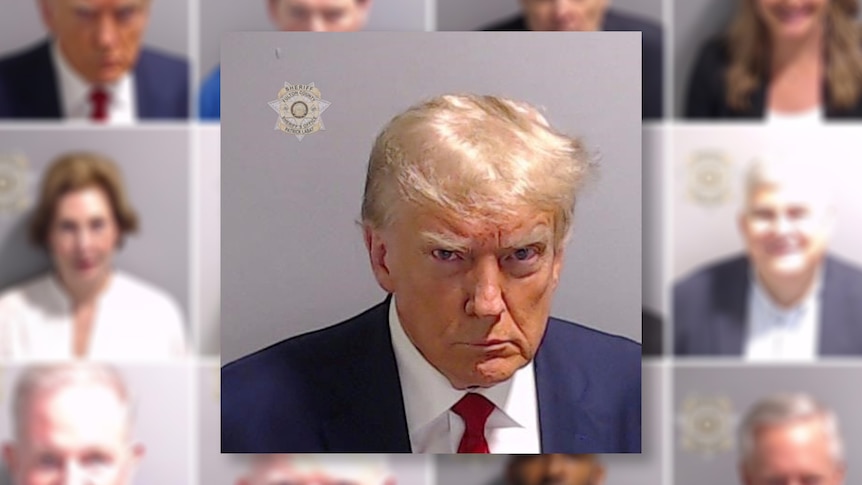 A stern looking Donald Trump looks into the camera, the Fulton County Sheriff's Office logo in the corner.