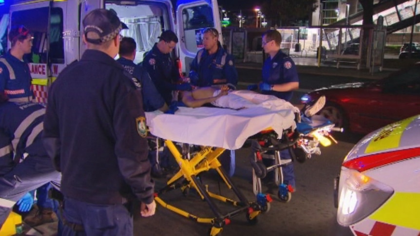 Paramedics treat a teenage stabbing victim.