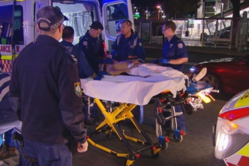 Paramedics treat a teenage stabbing victim.