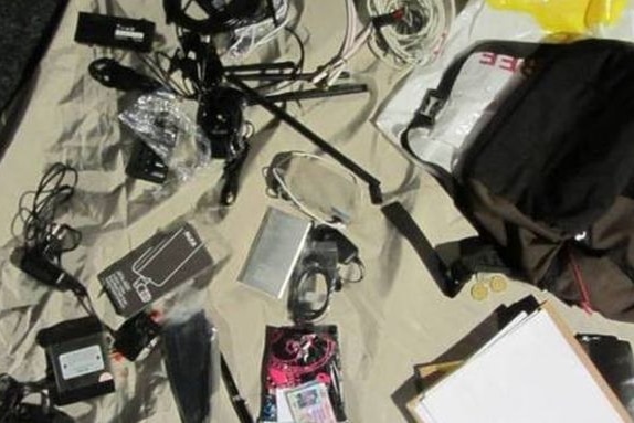 Surveillance equipment lies scattered on a bed